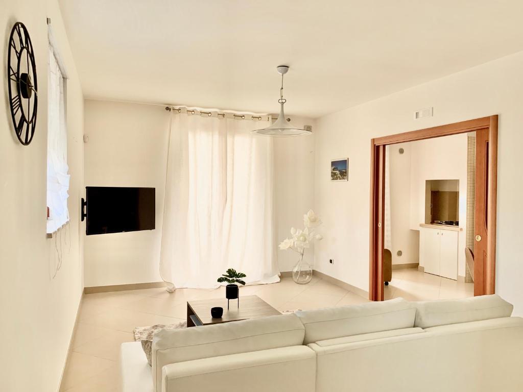 a white living room with a white couch at Dimora Anvi - Relax Fronte Mare in Polignano a Mare