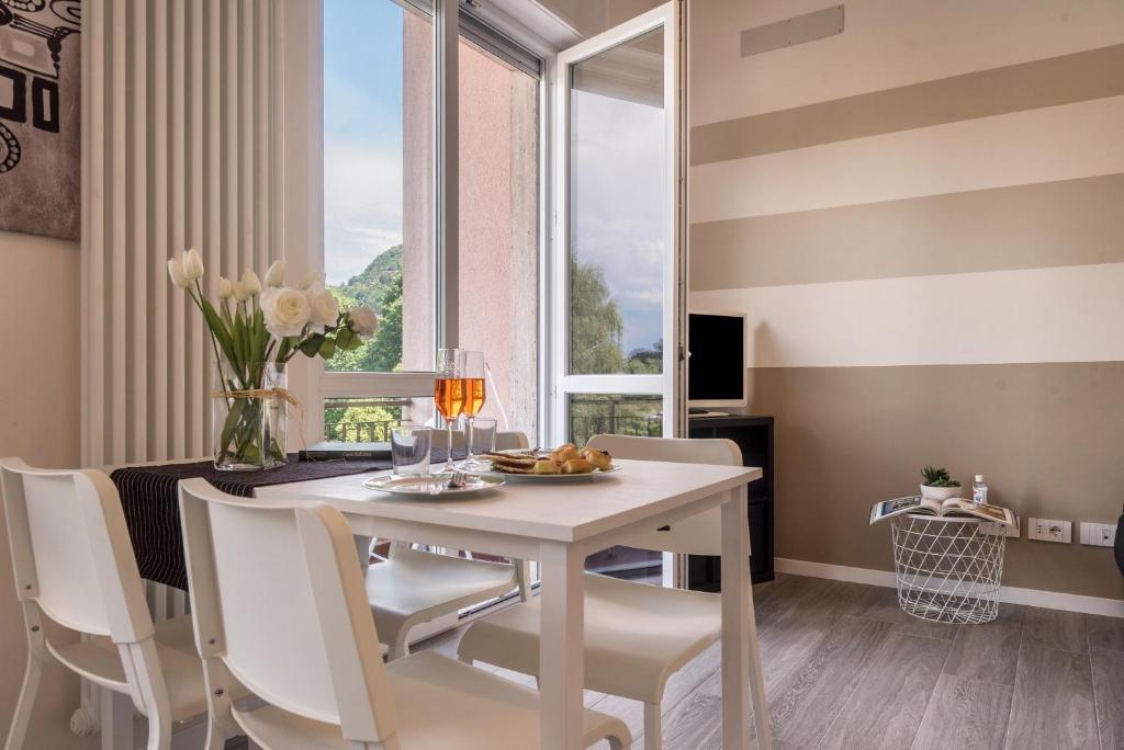 comedor con mesa, sillas y ventana en Maison Bibi Lago Maggiore, en Laveno-Mombello