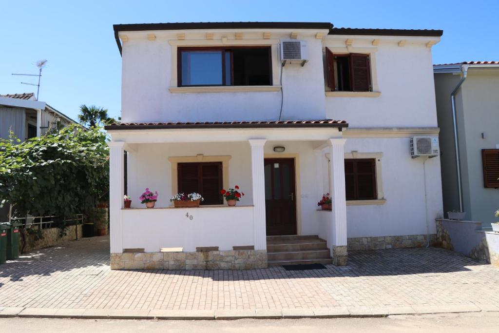 a white house with two windows and a door at Apartment Sole in Poreč