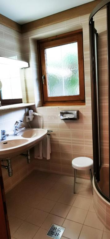 łazienka z umywalką, oknem i stołkiem w obiekcie Ferienwohnung w mieście Bad Kleinkirchheim