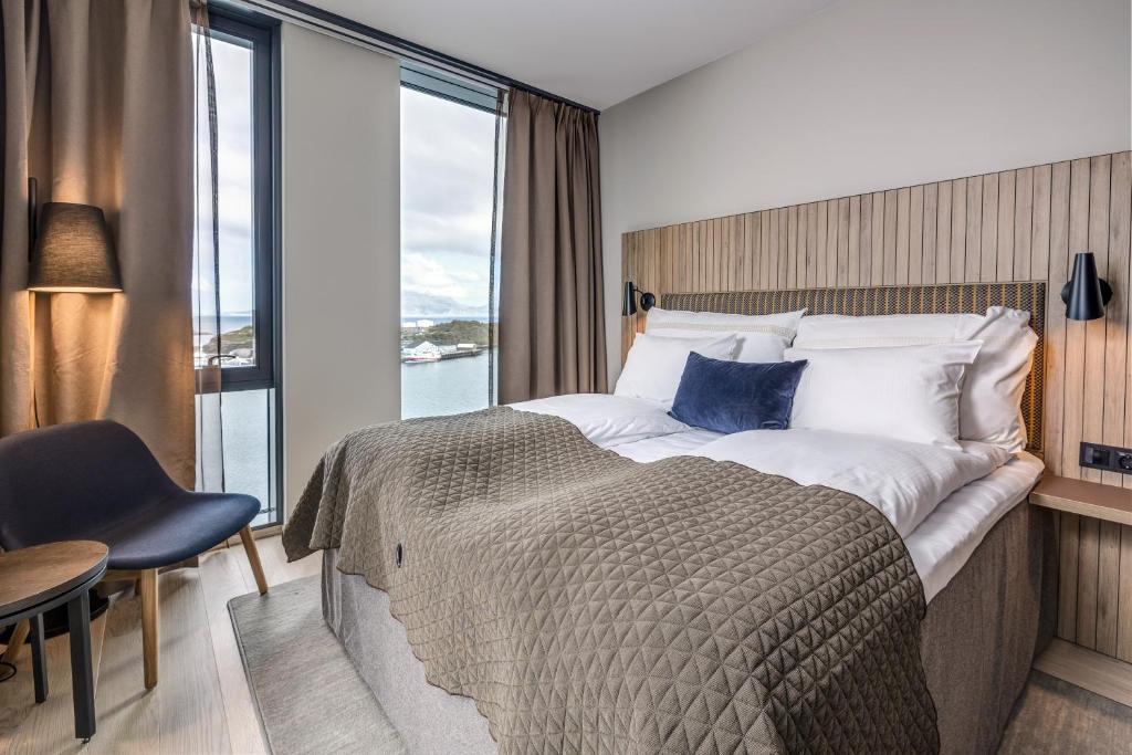 a bedroom with a large bed with a large window at Quality Hotel Ramsalt in Bodø
