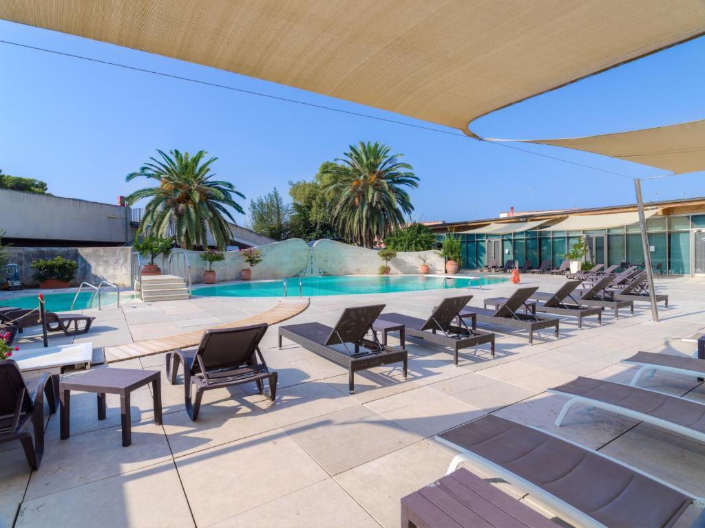 a pool with chaise lounge chairs and a swimming pool at Grand Hotel Tiziano E Dei Congressi in Lecce