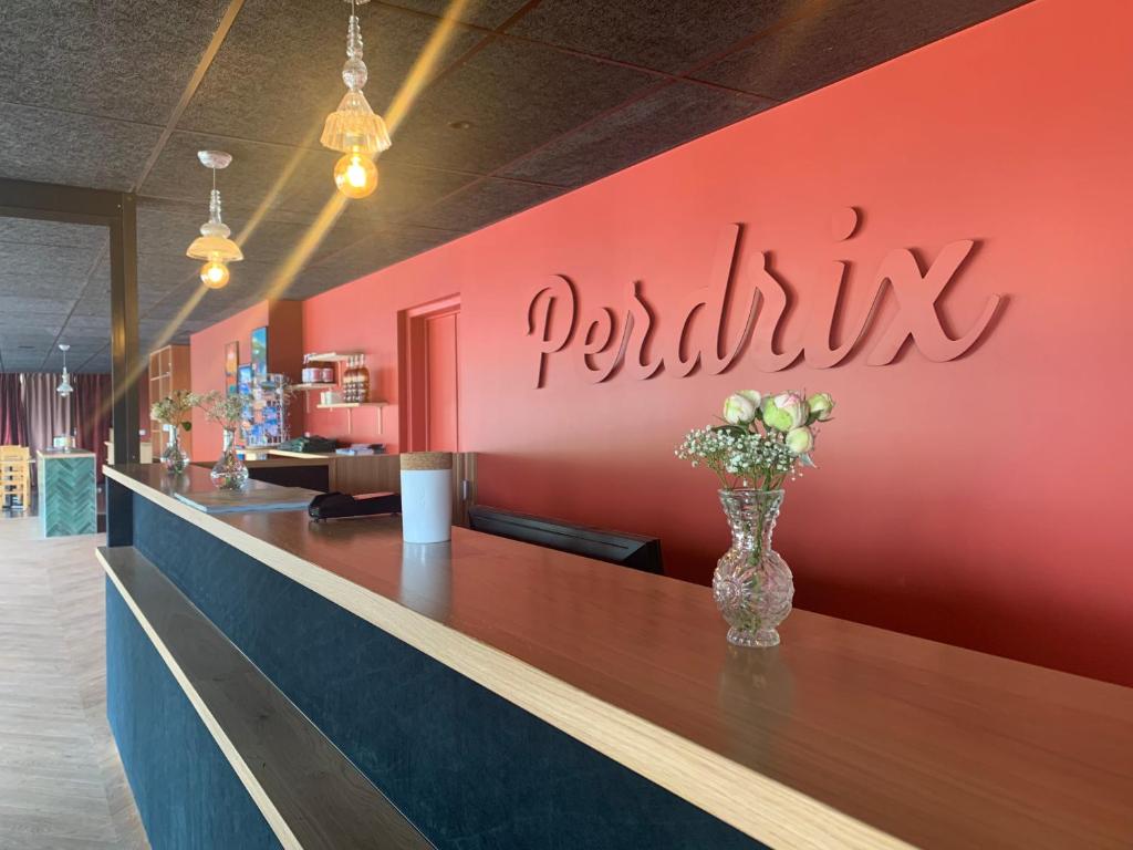 a bar in a restaurant with a vase of flowers at Hotel Perdrix in Super Besse