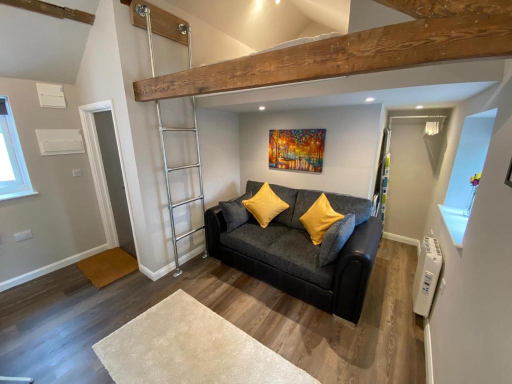 a living room with a couch in a loft at Apartment @ Bastion Mews in Hereford