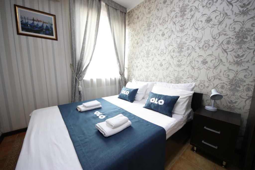 a bedroom with a bed with two towels on it at OLO Marsel Krasnodar Hotel in Krasnodar