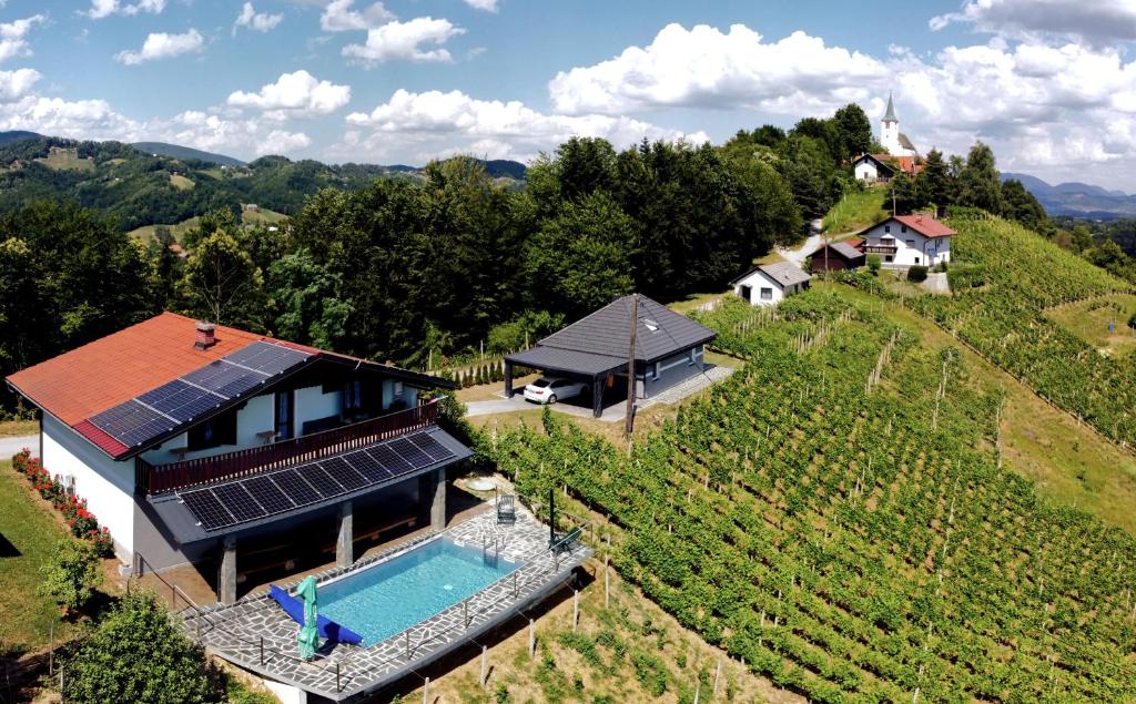 an aerial view of a house with solar panels on a hill at Vineyard Paradise Senica in Dramlje
