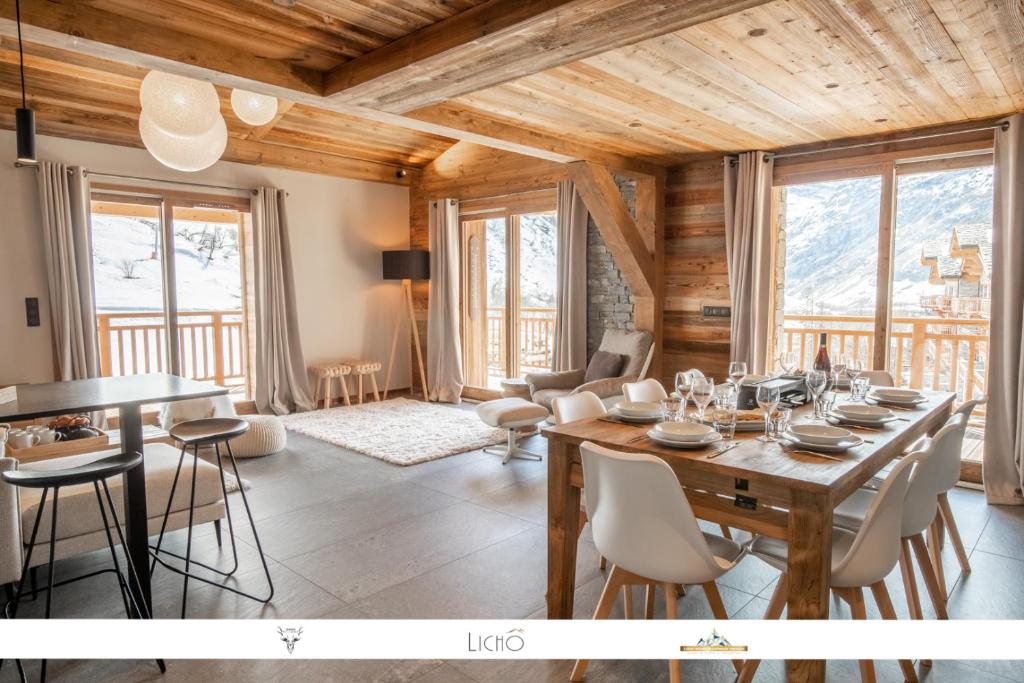 sala de estar con techo de madera, mesa y sillas en Marmotte 205 - Splendide duplex aux pieds des pistes en Bonneval-sur-Arc