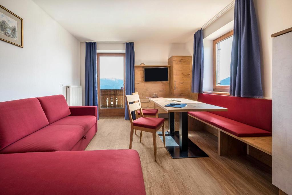 sala de estar con sofá rojo y mesa en Residence Condor Apt Rosengarten en Maranza