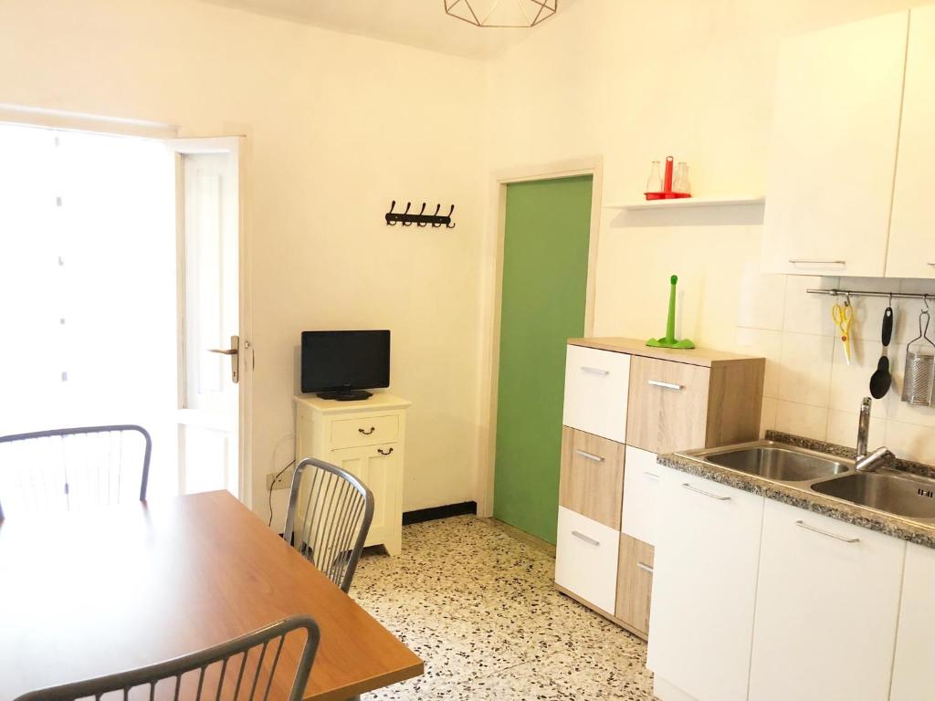 a kitchen with a sink and a table with chairs at Oasi del Pescatore in Marina di Cecina