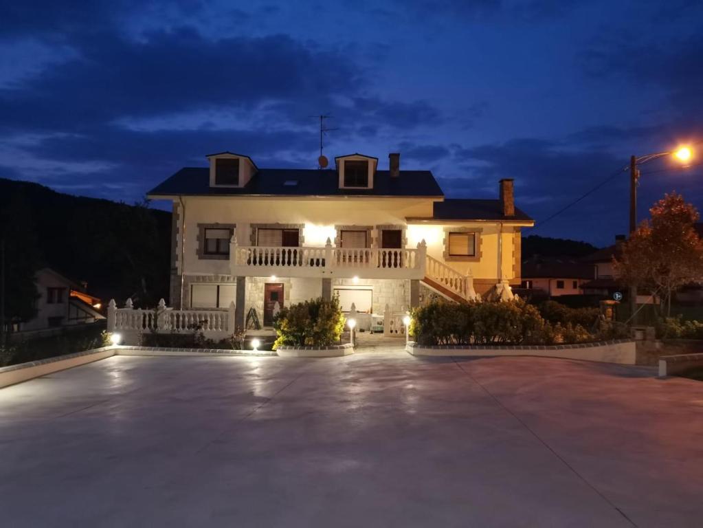 a large white house with a driveway at night at Casa La Quintana in Castro-Urdiales