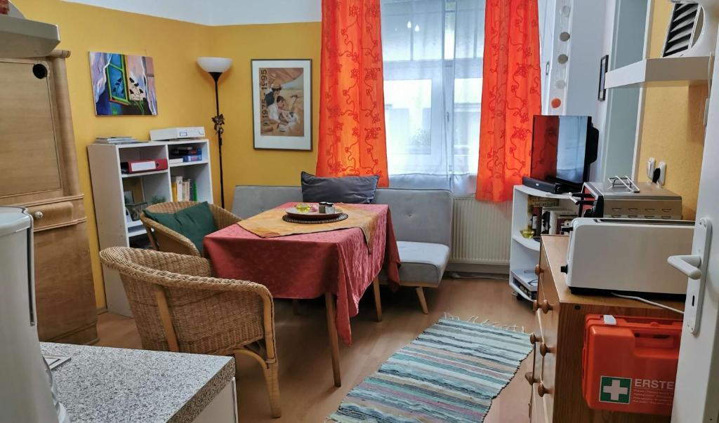ein Wohnzimmer mit einem Tisch und Stühlen sowie eine Küche in der Unterkunft Ferienwohnung in idyllischer Lage in Sauerthal