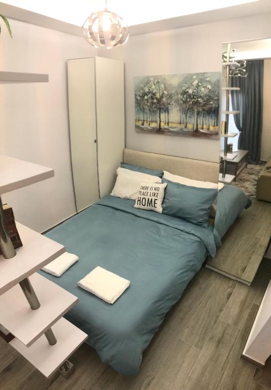 Schlafzimmer mit einem Bett mit blauer Decke in der Unterkunft Cosy studio 35m2 in Síndos