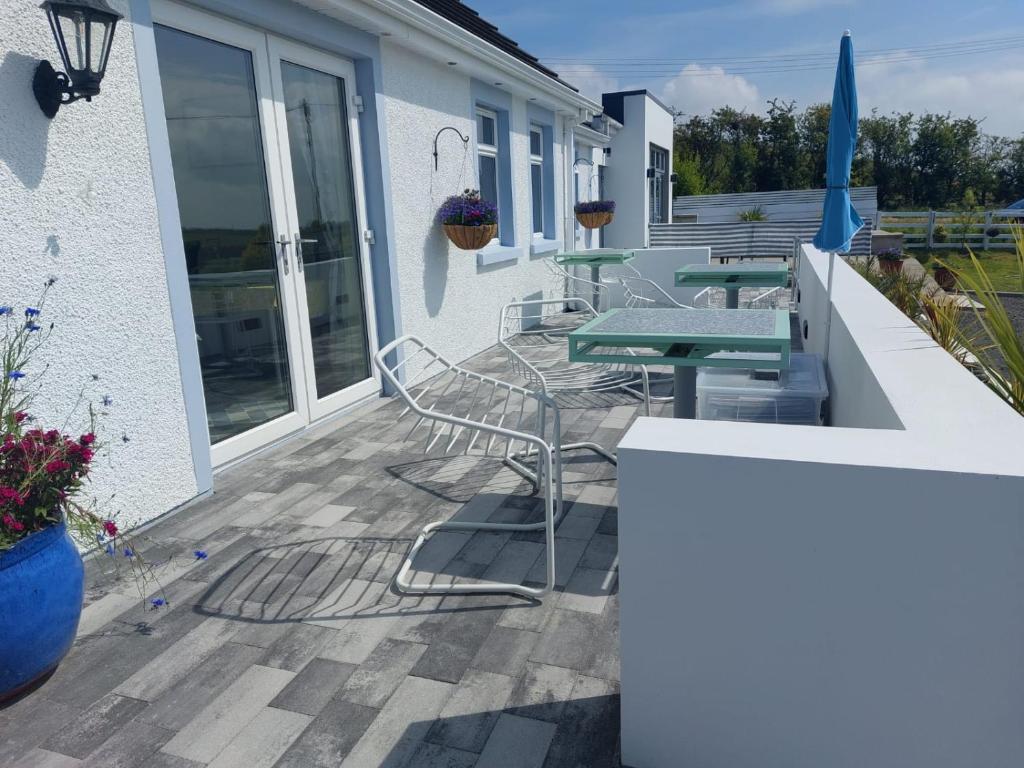 a patio with a table and chairs on a house at Rest a While in Bushmills