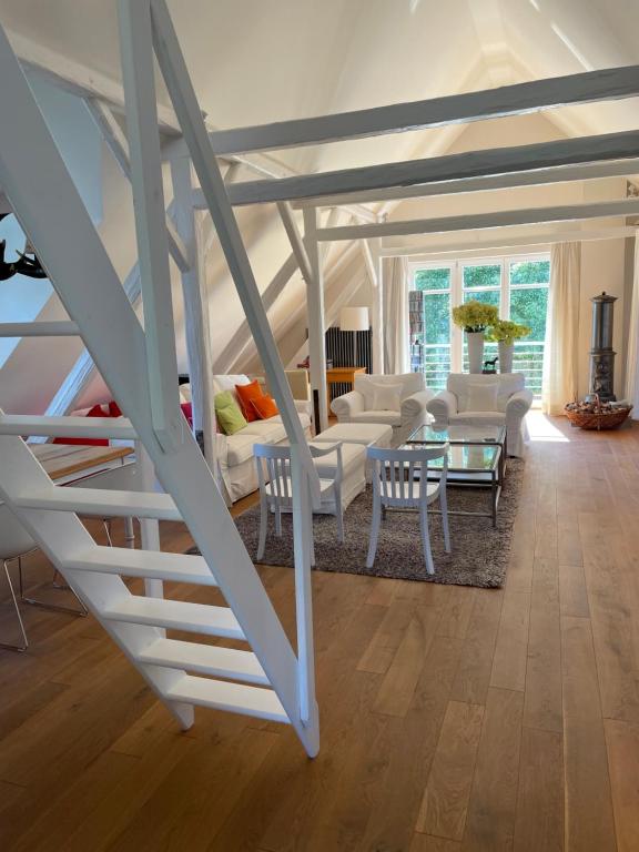 a living room with white furniture and a staircase at Landhaus am Rheinsteig & Loreley in Lykershausen