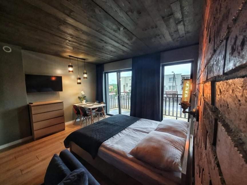 a bedroom with a large bed and a dining room at Loft 66 Apartamenty in Władysławowo