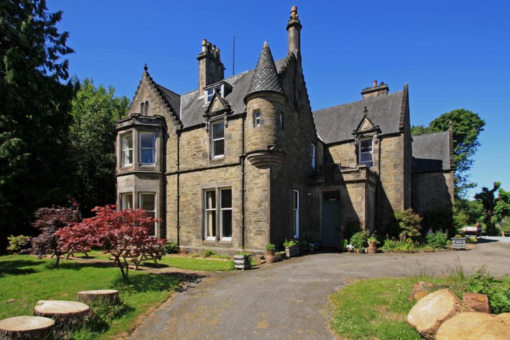 an old stone house with a driveway at Isla Bank House in Keith