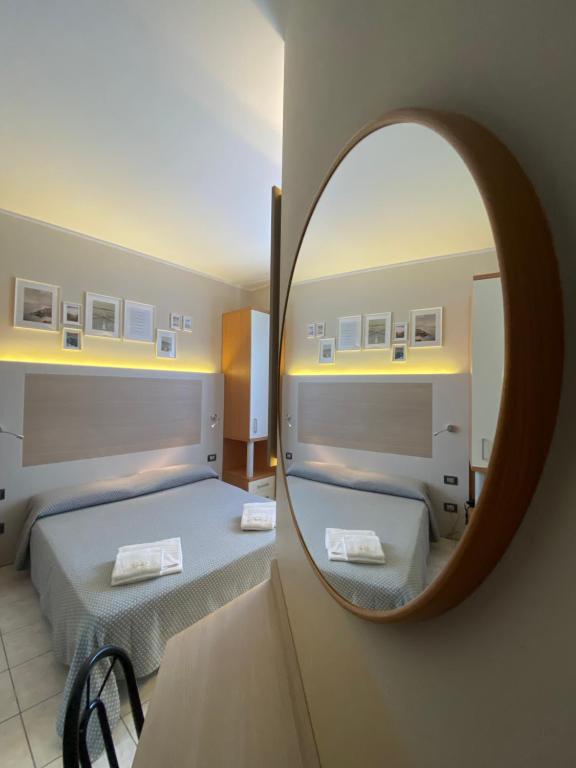 ミラノにあるホテル ドゥエ ジャルディーニの鏡に映るベッドルーム(ベッド2台付)