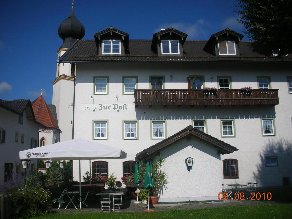 un gran edificio blanco con un balcón en la parte superior. en Gasthof zur Post en Schonstett