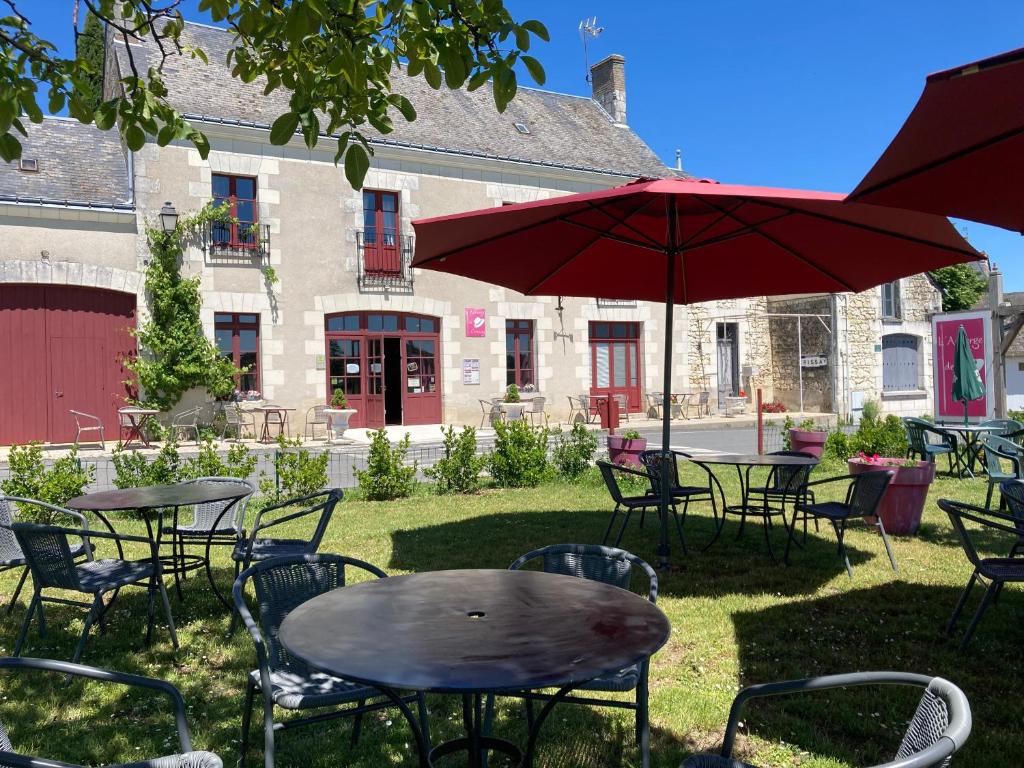 d'une terrasse avec des tables, des chaises et un parasol. dans l'établissement Logis Auberge de Crissay, à Crissay-sur-Manse