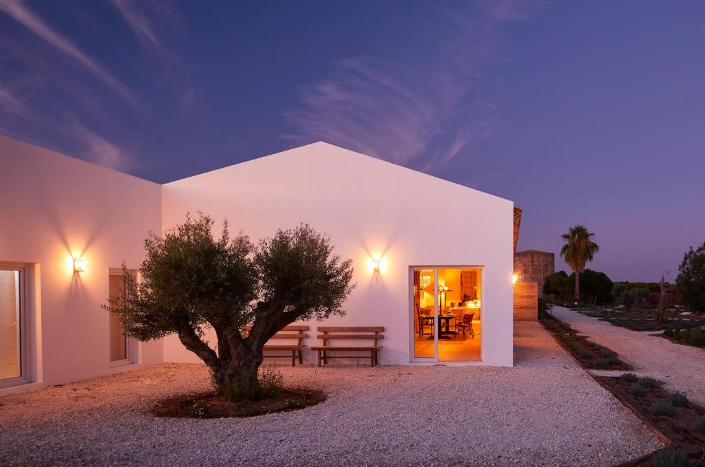 un bâtiment blanc avec un arbre devant lui dans l'établissement Rufino Quinta, à Estevais