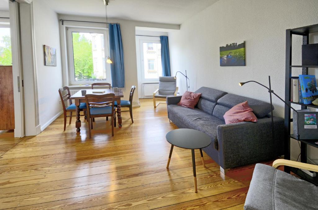 een woonkamer met een bank en een tafel bij fewo1846 - Parkblick - komfortable Wohnung mit 2 Schlafzimmern und 2 Balkonen in Flensburg