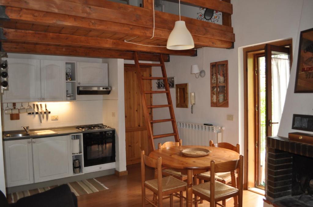 uma cozinha com uma mesa de madeira e uma escada em Appartamento ad Ovindoli em Ovindoli