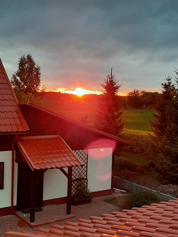 una vista de la puesta de sol desde el techo de una casa en Pod żurawiem Szwałk 1 en Swiętajno