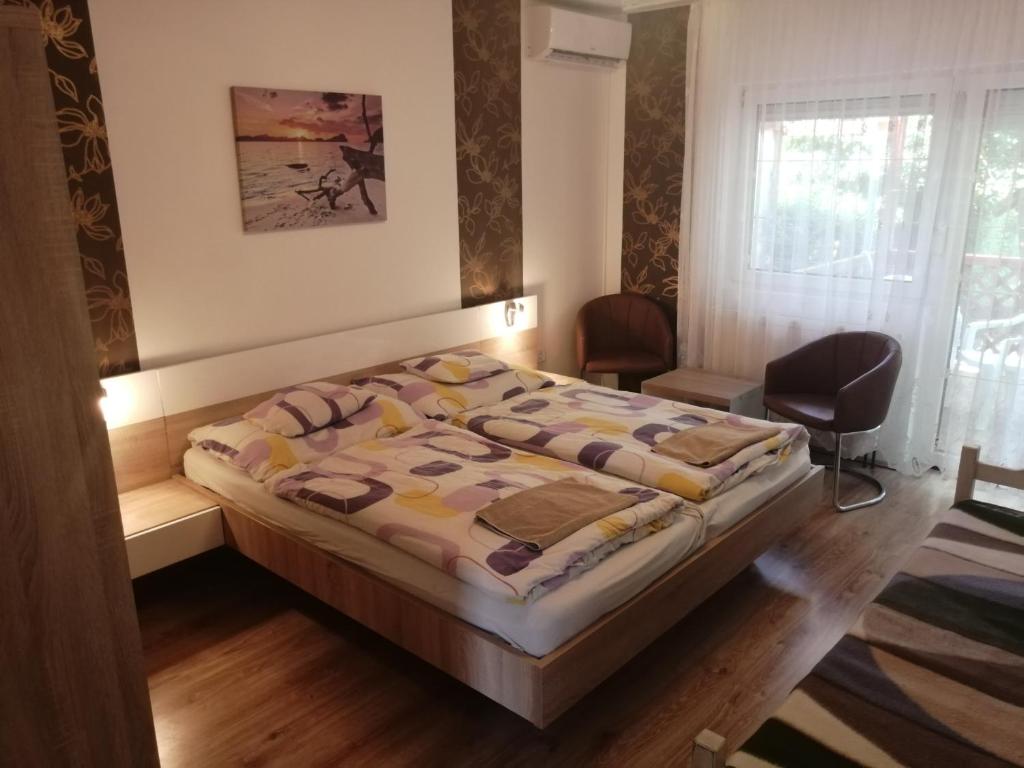 A bed or beds in a room at Loki Apartman