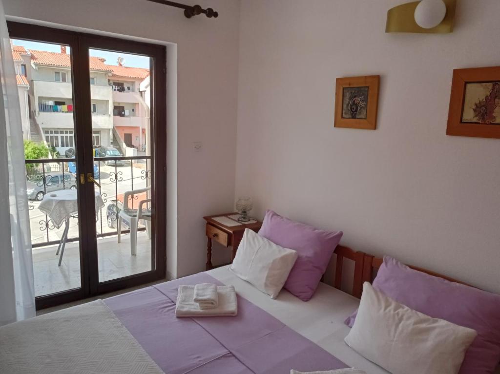 a bedroom with a bed with purple and white pillows at "Sunny" - Studio Apartment in Pula