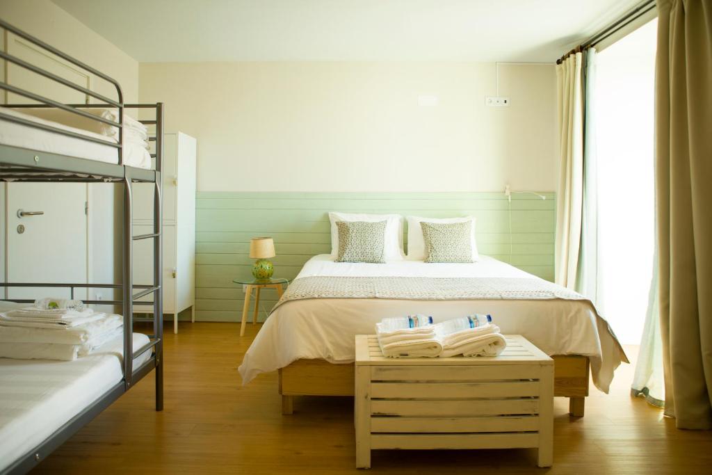 a bedroom with a bed and a desk at THE HOLY COW - Hostel & Suites in Ponta Delgada