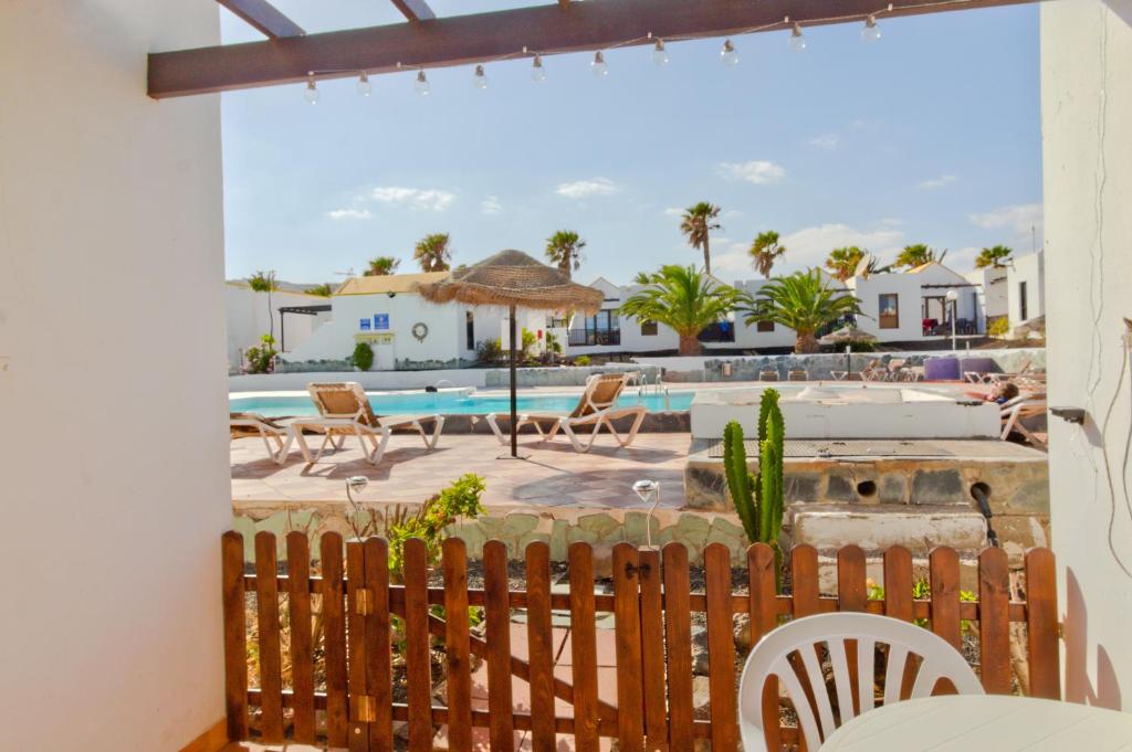 Vom Balkon einer Villa genießen Sie Poolblick. in der Unterkunft Casa Maria N2 Montecastillo in Caleta de Fuste