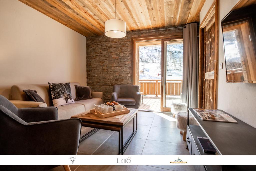 un soggiorno con divano e tavolo di MARMOTTE 004 - Charmant appartement pour 6, aux pieds des pistes a Bonneval-sur-Arc