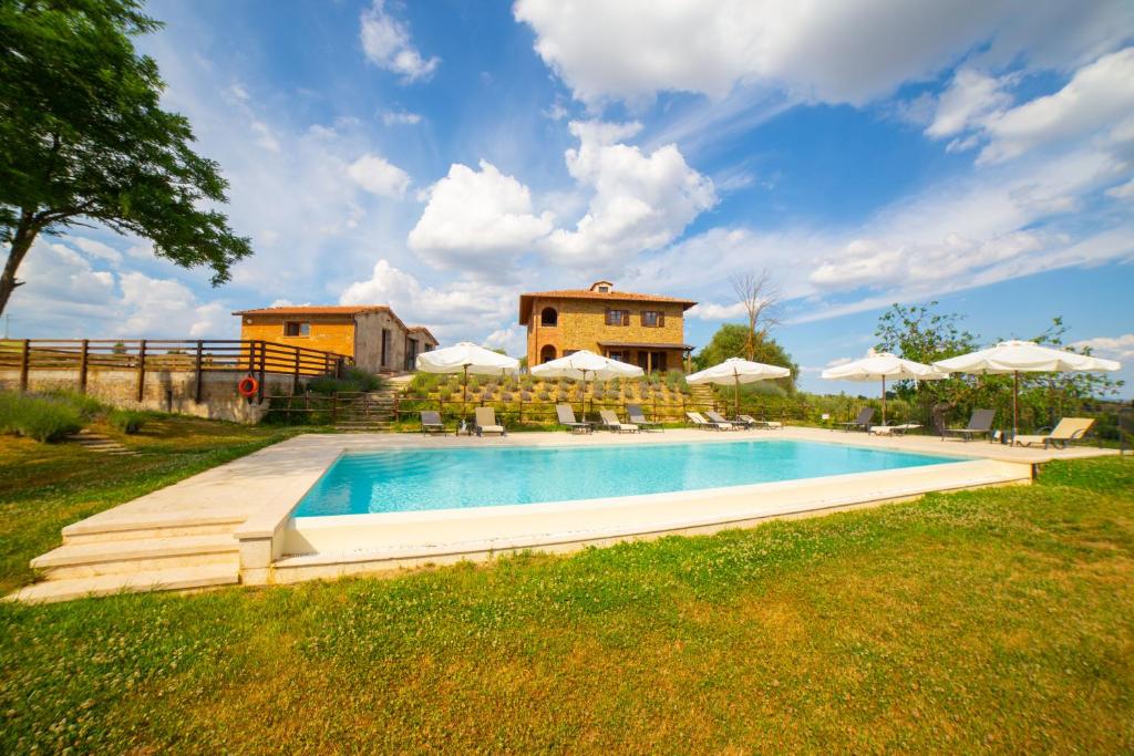 蒙特普齐亚诺Tuscany Living - Terra Antica的房子旁边有带椅子和遮阳伞的游泳池