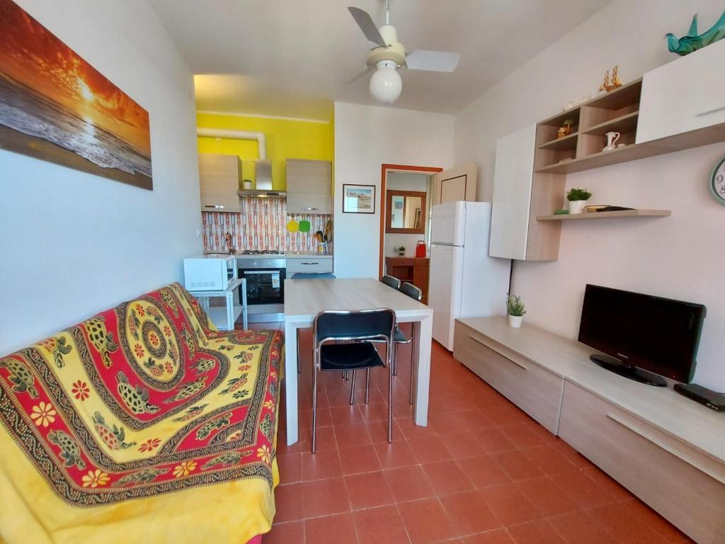 sala de estar y cocina con mesa y sofá en Luisa 5B, en Lido di Pomposa