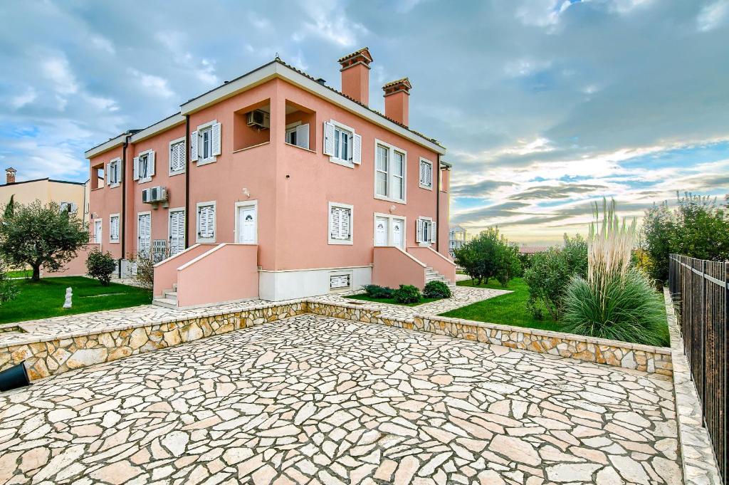 una gran casa rosa con entrada de piedra en Medulin Luxury Apartments with beautiful garden 100 m from beach en Medulin