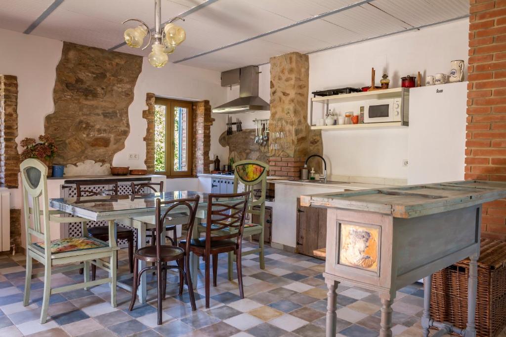 een keuken met een tafel en stoelen in een kamer bij Casa Rural Castillo JABUGO in Jabugo