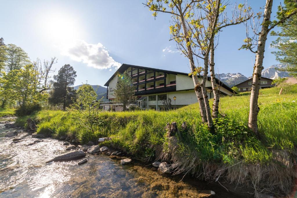 una casa en una colina junto a un río en Berg & Bett Säntis Lodge en Unterwasser
