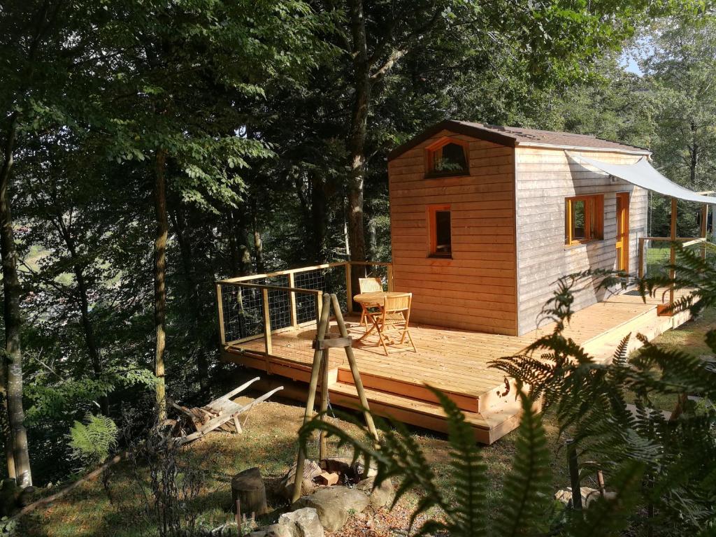 a small cabin with a deck in the woods at Giteovosges in La Croix-aux-Mines