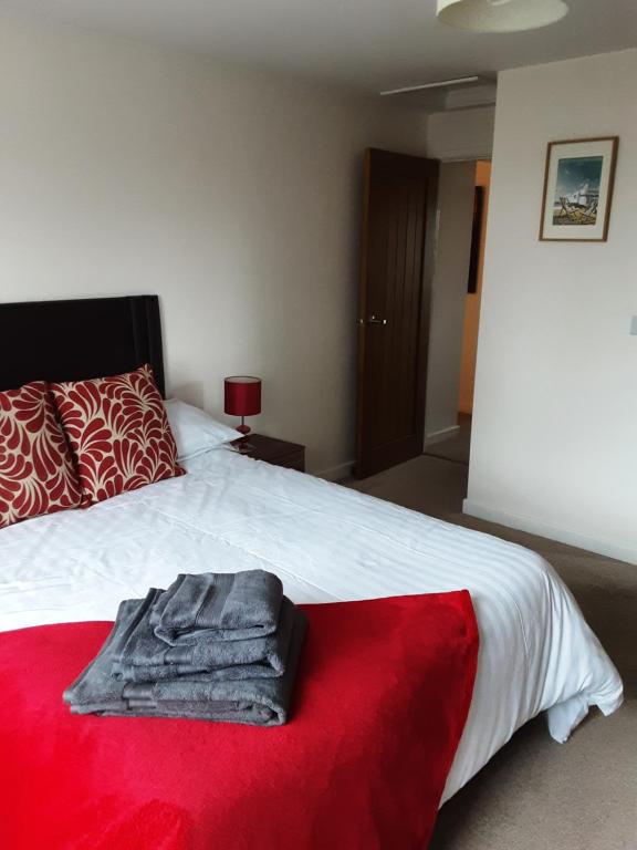 sypialnia z łóżkiem z czerwonym kocem w obiekcie Snoozefrome w mieście Frome