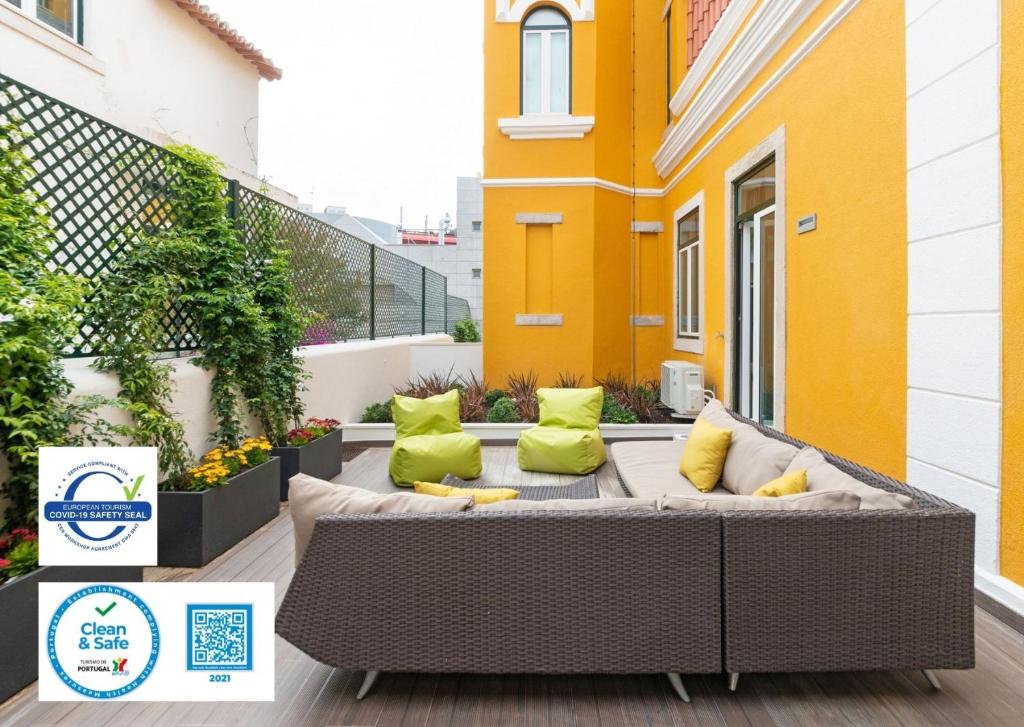 d'une terrasse avec un canapé et des oreillers sur un balcon. dans l'établissement Bela Vista Palace Apartments, à Cascais