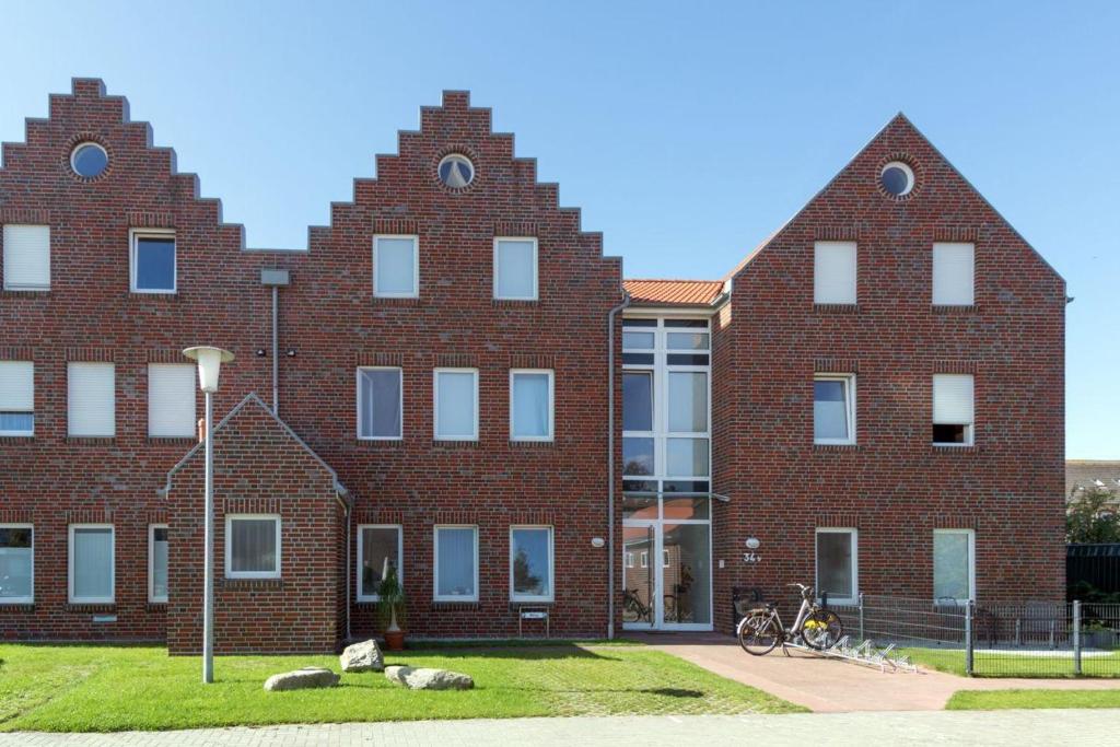 a large brick building with two large windows at Norddeich-Loft-Wohnung-mit-Kamin in Norden