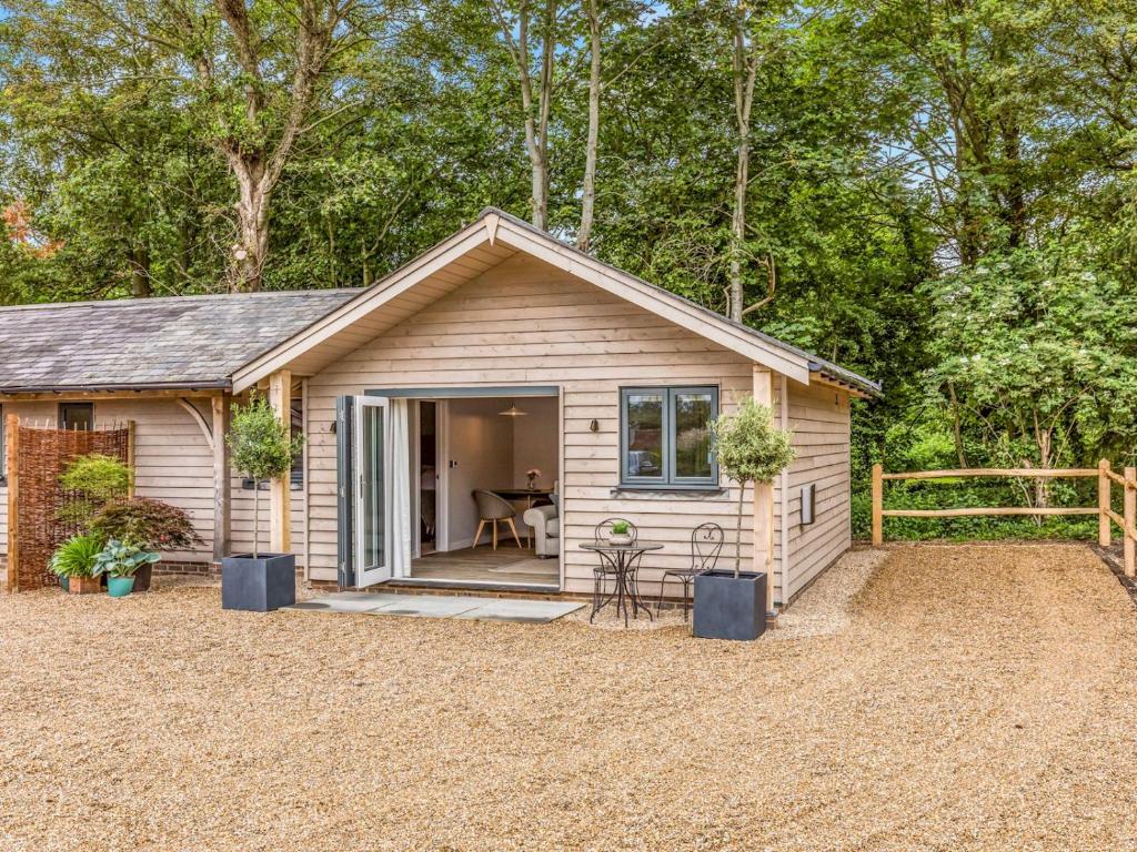 ein kleines Haus mit einer Veranda und einer Terrasse in der Unterkunft Pass the Keys Delightful 1 bed lodge in South Downs village in Chichester