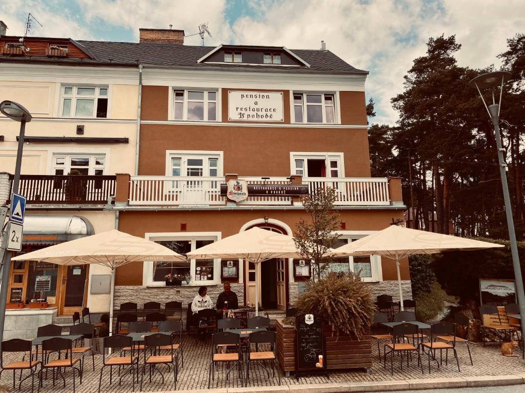 a restaurant with tables and umbrellas in front of a building at Pension V Pohodě in Konstantinovy Lázně