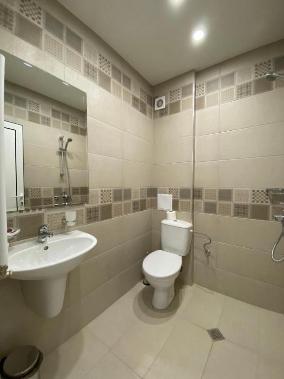 ein Badezimmer mit Toilette und Waschbecken in der Unterkunft Edelweiss Central Hotel in Bansko