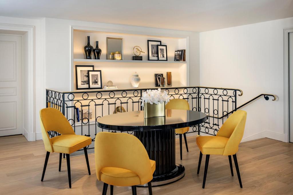 a dining room with a table and yellow chairs at InterContinental Paris Le Grand by IHG in Paris