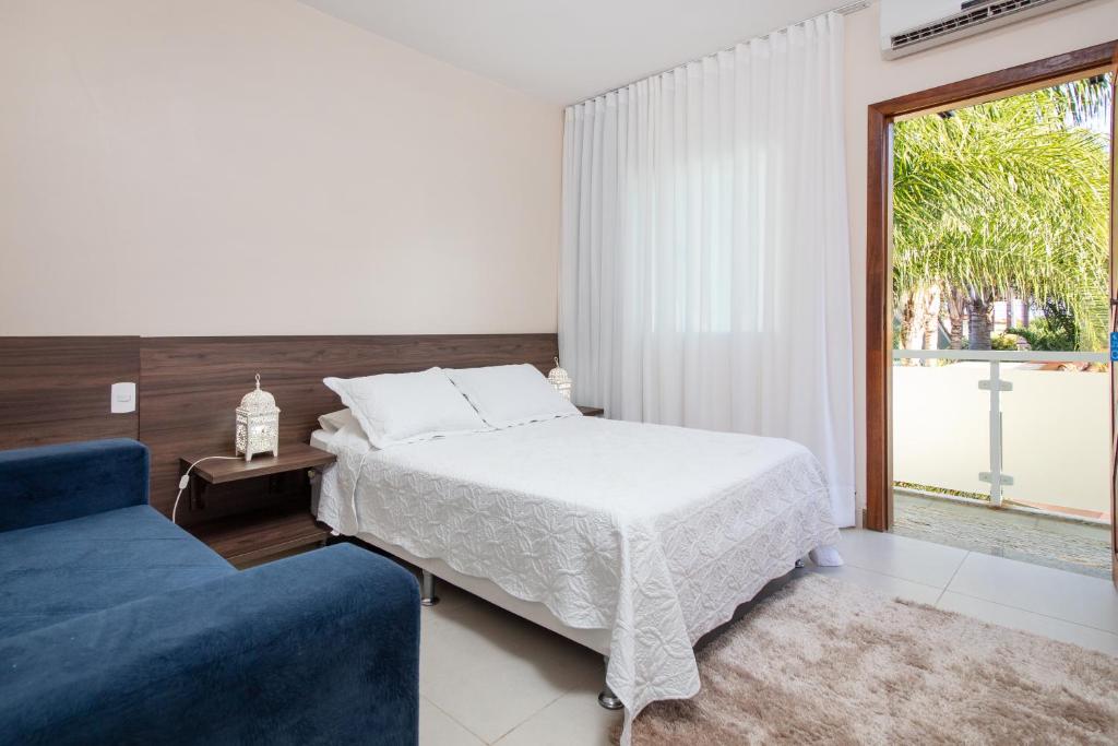 1 dormitorio con 1 cama y 1 sofá azul en Luar de Geribá en Búzios