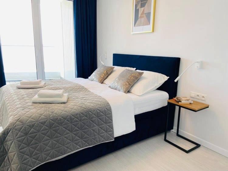 1 dormitorio con 1 cama grande y mesita de noche en Rogowo Pearl Apartament Resko en Rogowo