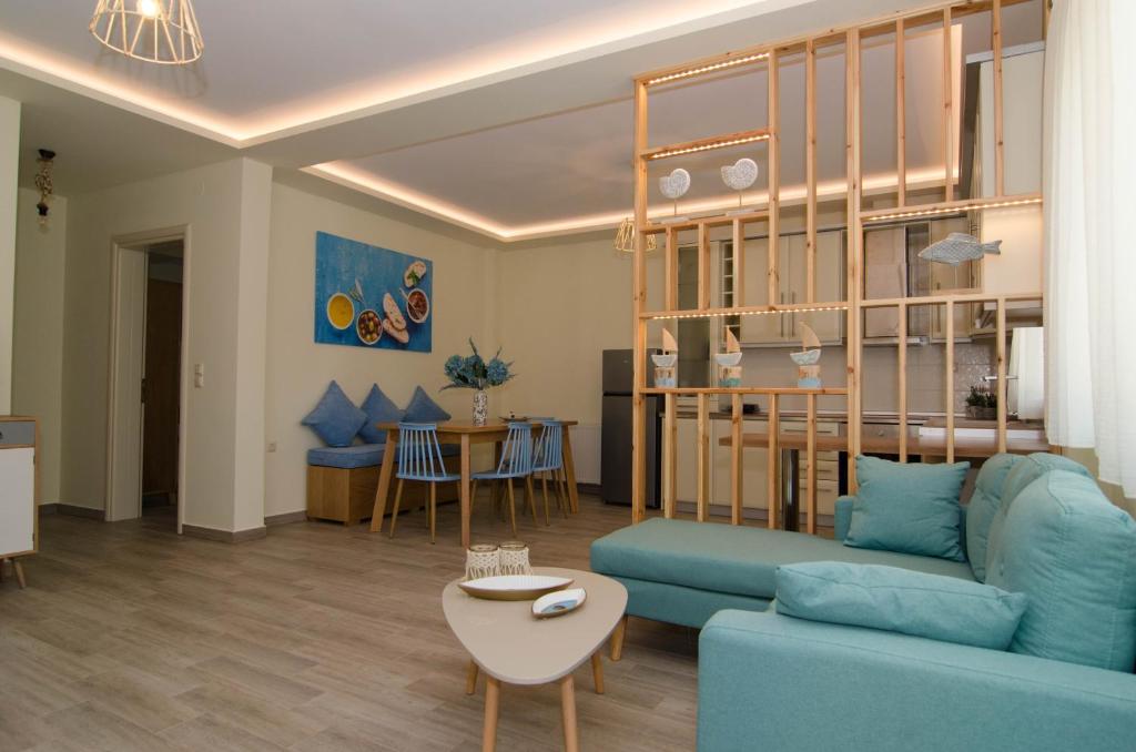 a living room with a blue couch and a table at L & A - GUEST HOUSE in Skala Potamias