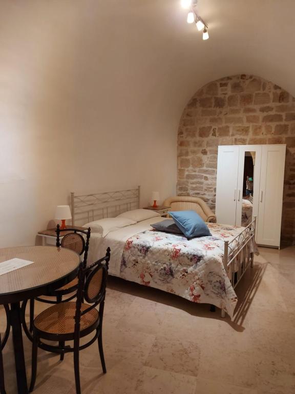 ein Schlafzimmer mit einem Bett und einem Tisch in einem Zimmer in der Unterkunft Ai Carrettieri in Trani