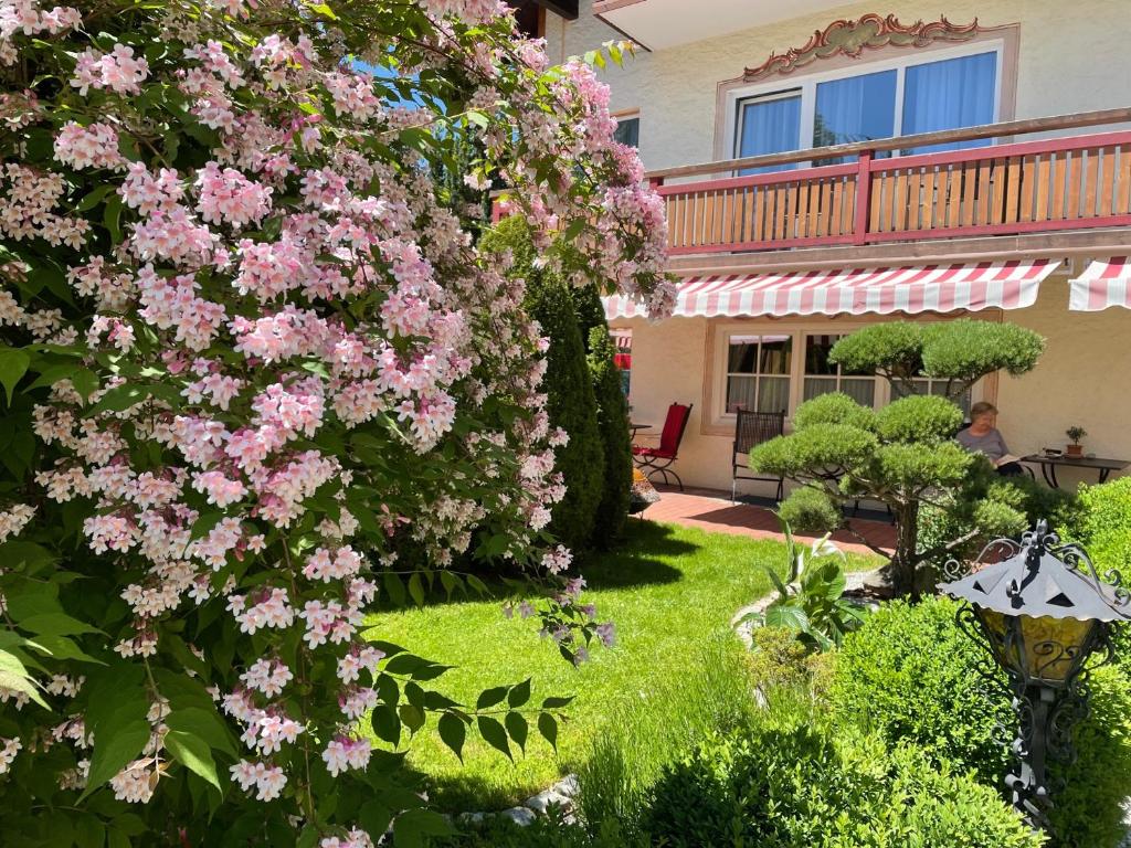 a bush with pink flowers in a yard at Das Johannesbad - DAS MEDICAL SPA & VITAL REFUGIUM in Bad Kohlgrub